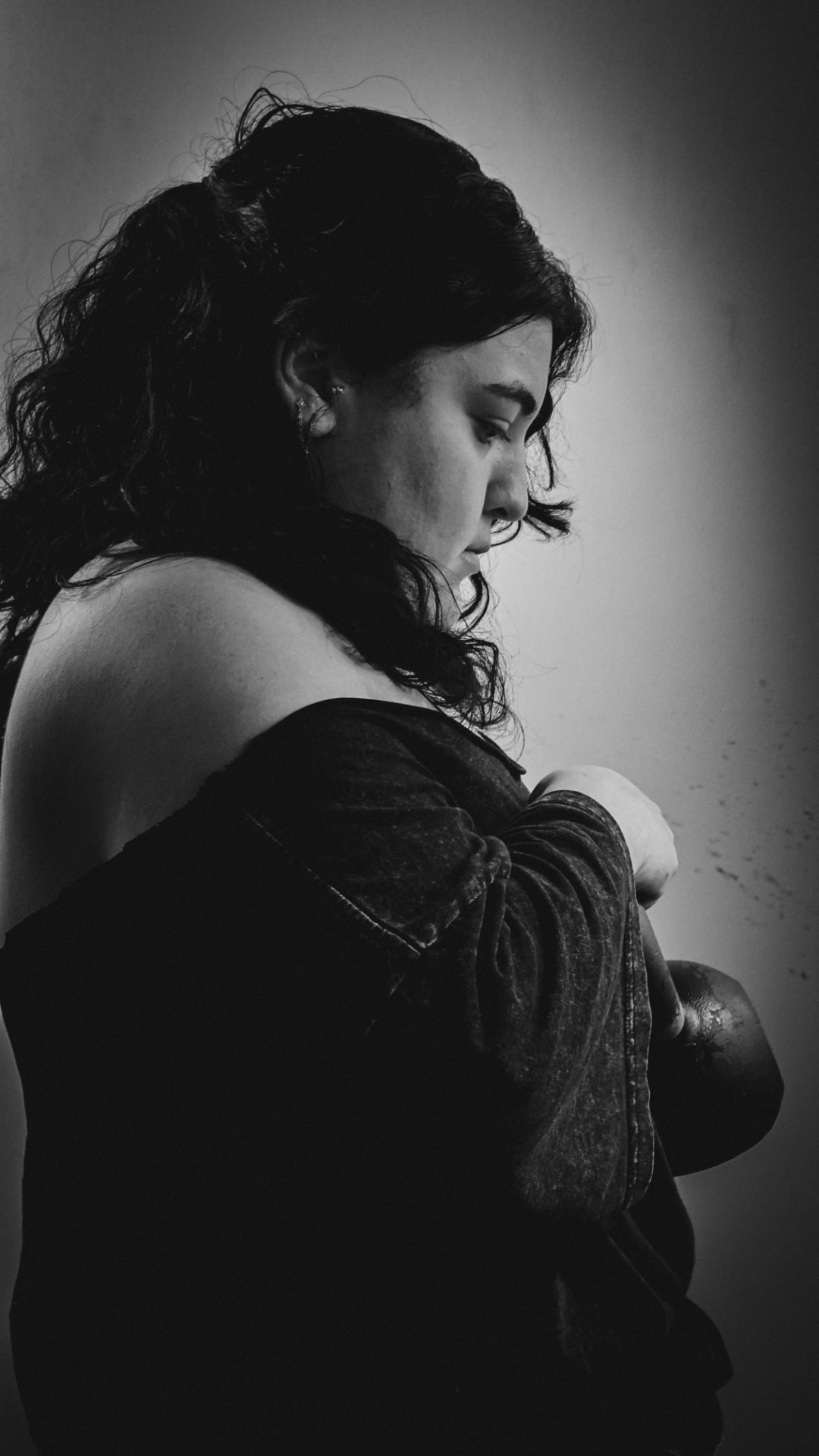 Woman in profile holding a kettlebell, black and white