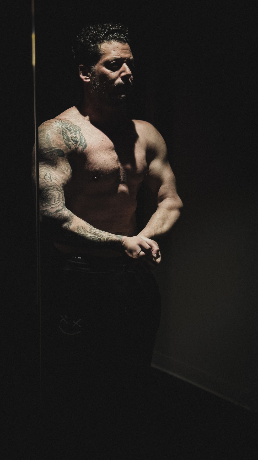 Low-key gym portrait beside a reflection