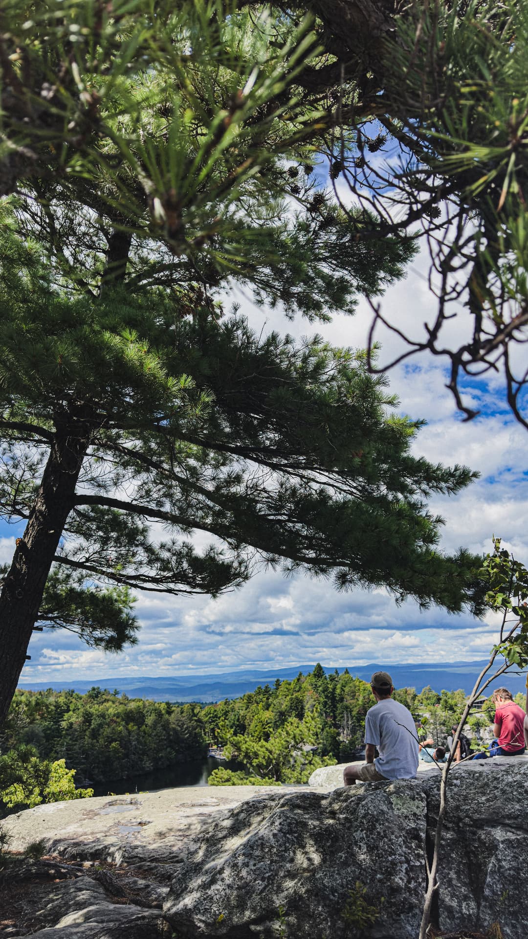 Seated figures resting at a mountain overlook above the valley
